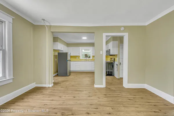 a view of a big room with wooden floor and a kitchen
