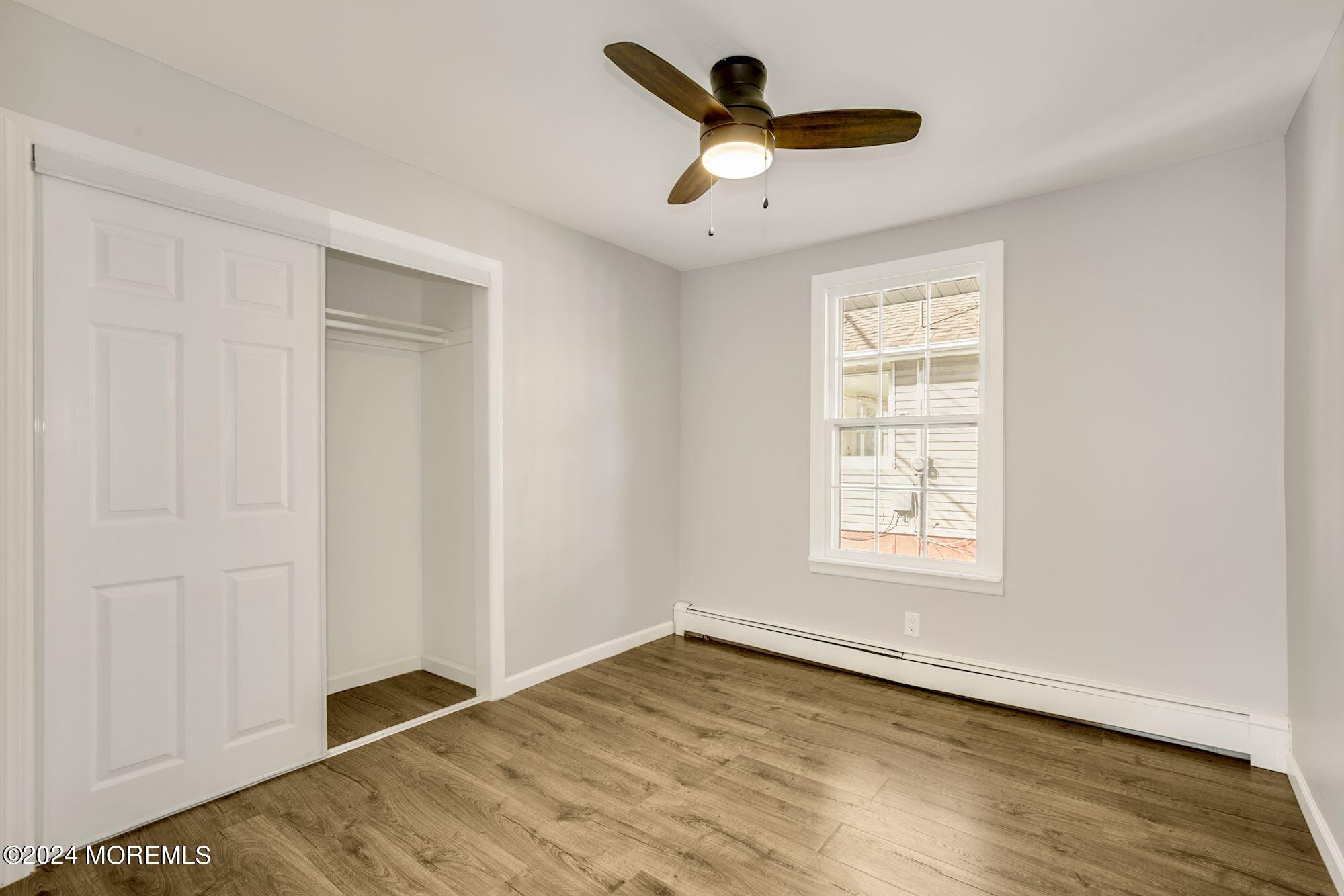 198 Newman Springs Road Red Bank, NJ 07701 - Photo 8 of 13 an empty room with wooden floor chandelier fan and windows
