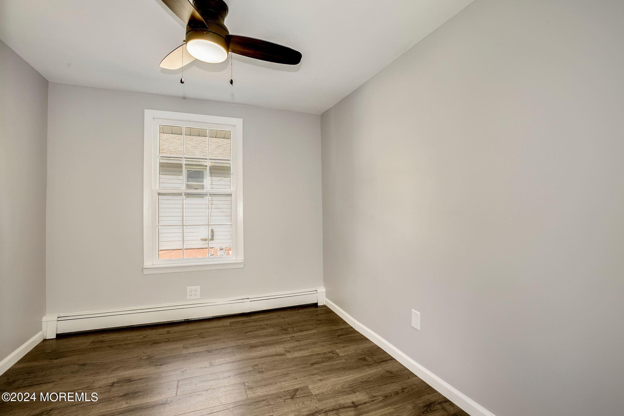 198 Newman Springs Road Red Bank, NJ 07701 - Photo 9 of 13 an empty room with wooden floor chandelier fan and windows