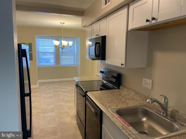 17439 Hughes Road Poolesville, MD 20837 - Photo 10 of 25 a kitchen with a sink a microwave and cabinets