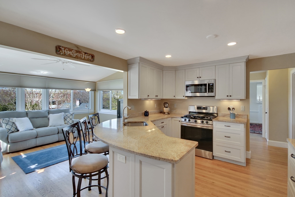 106 Channing Road Watertown, MA 02472 - Photo 14 of 39 a large kitchen with stainless steel appliances granite countertop a stove a sink a refrigerator and white cabinets with wooden floor