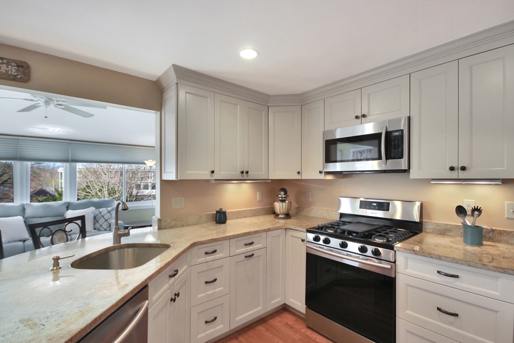 106 Channing Road Watertown, MA 02472 - Photo 3 of 39 a kitchen with granite countertop white cabinets and stainless steel appliances