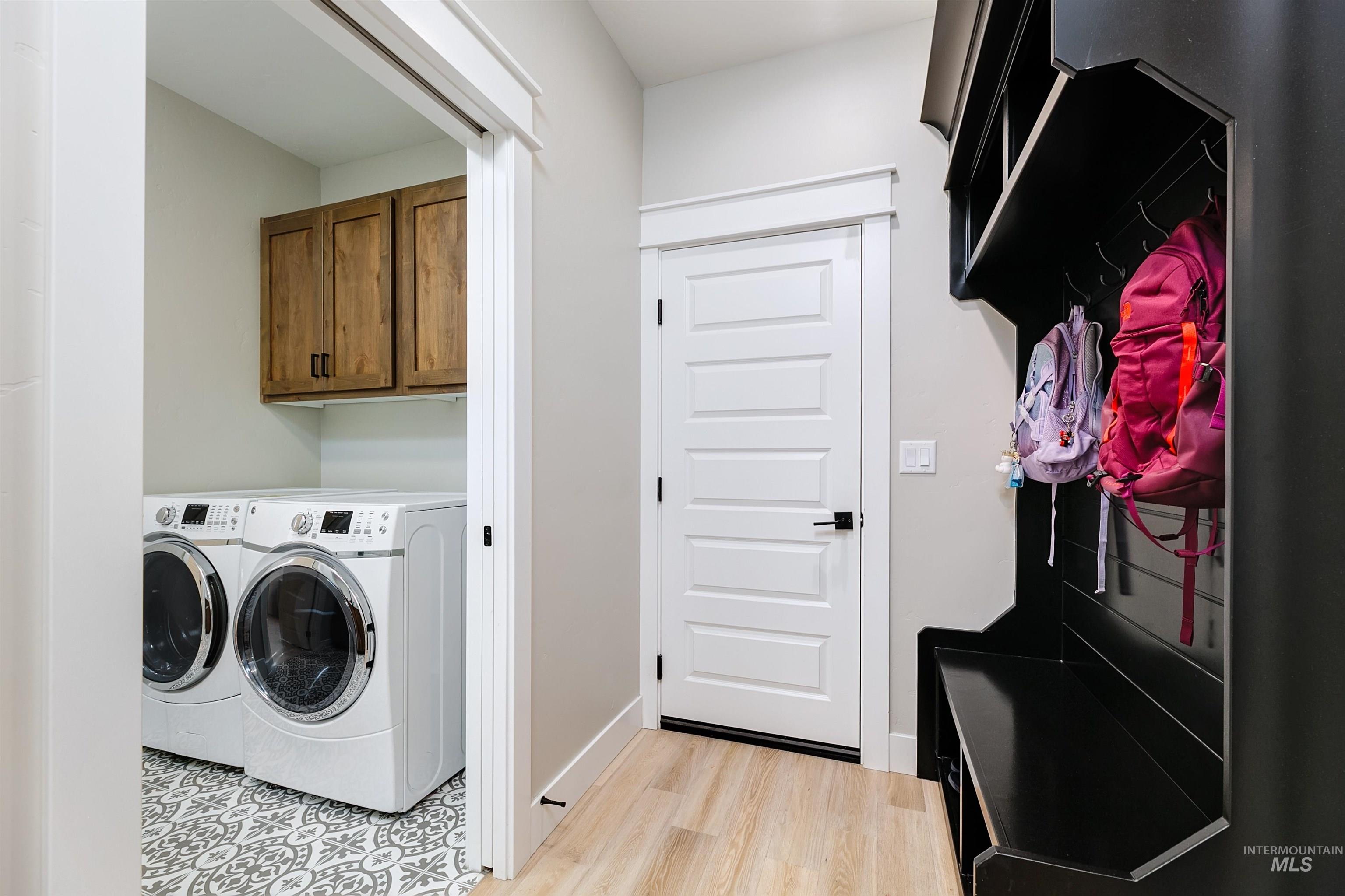 5463 North Exeter Way Meridian, ID 83646 - Photo 22 of 36 Laundry room with separate washer and dryer, light wood finished floors, and cabinet space