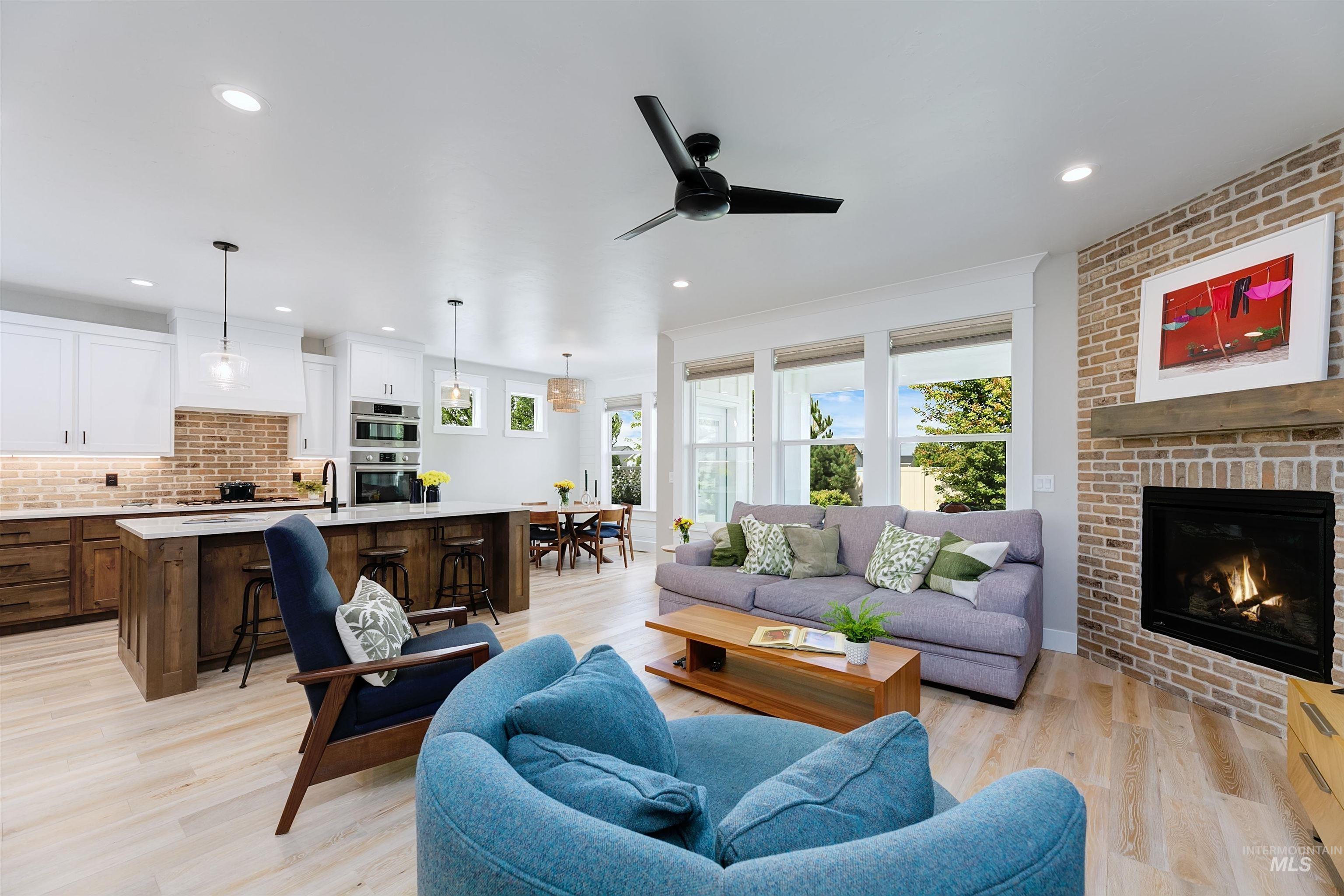 5463 North Exeter Way Meridian, ID 83646 - Photo 5 of 36 Featuring luxury vinyl plank flooring, contemporary floor to ceiling brick fireplace, and recessed lighting.