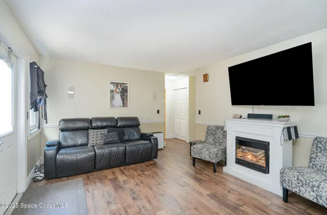 a living room with furniture a flat screen tv and a fireplace