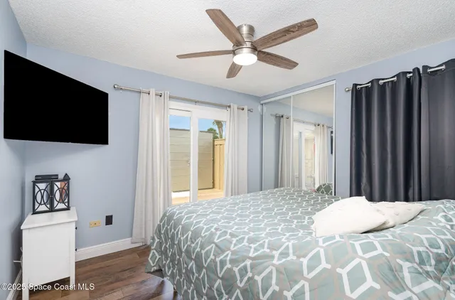 a bedroom with a large bed a flat tv screen and a walk in closet