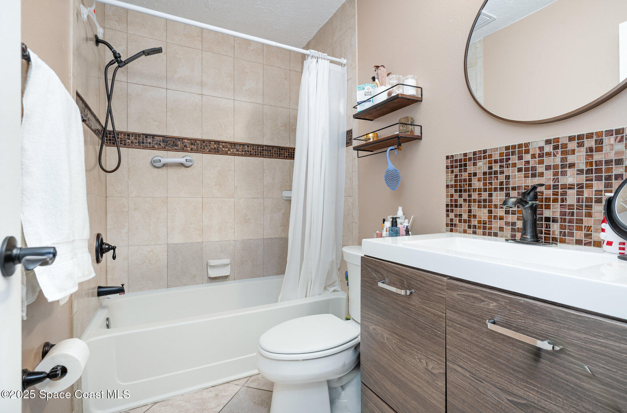 1010 Abada Court Northeast, Unit 102 Palm Bay, FL 32905 - Photo 16 of 37 a bathroom with a sink a toilet and a mirror