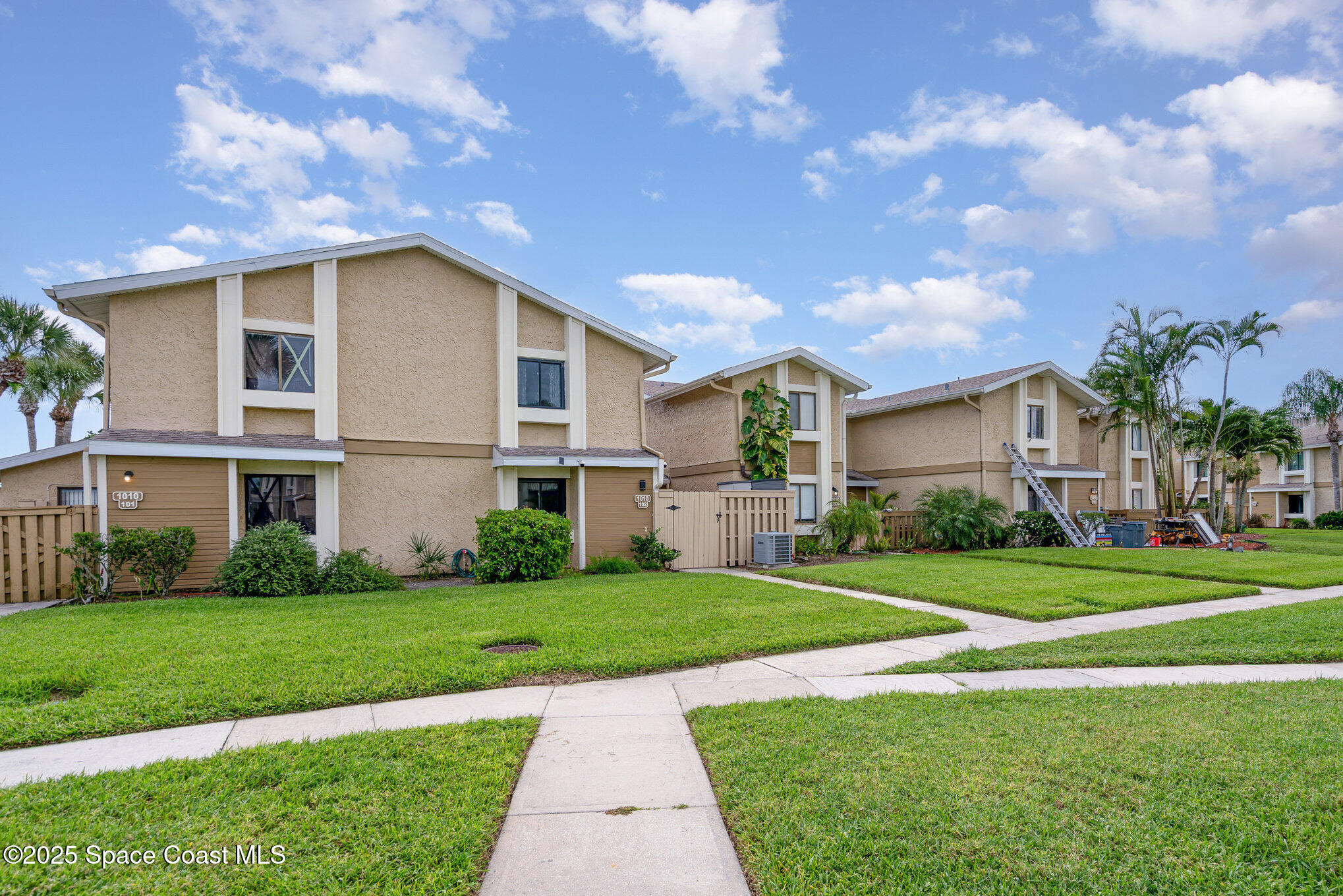 1010 Abada Court Northeast, Unit 102 Palm Bay, FL 32905 - Photo 2 of 37 a front view of a house with a yard
