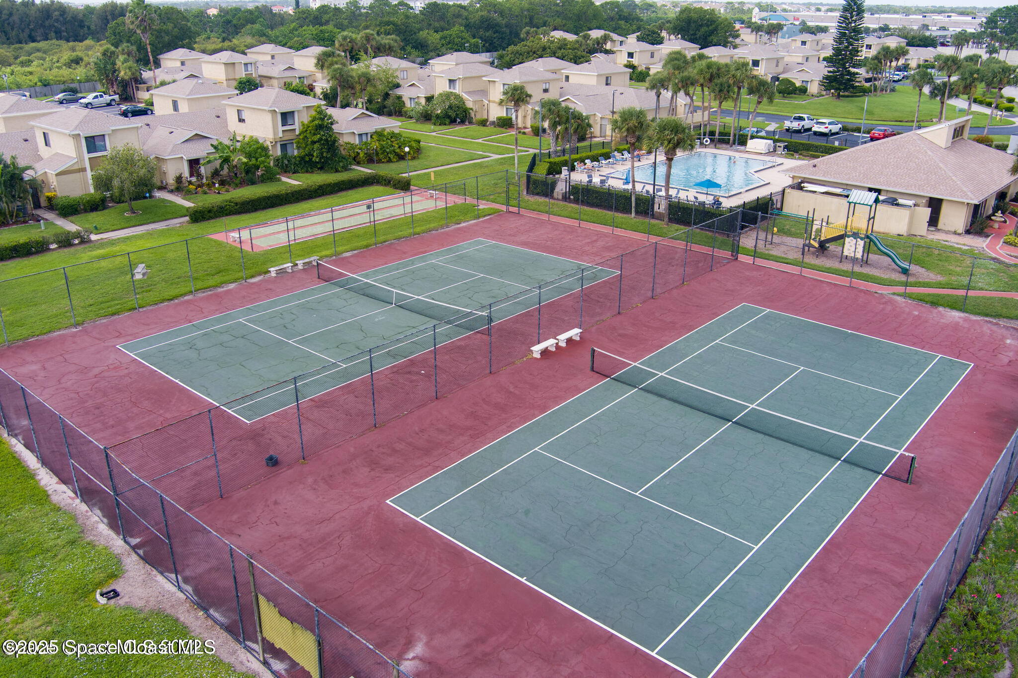1010 Abada Court Northeast, Unit 102 Palm Bay, FL 32905 - Photo 30 of 37 an aerial view of a tennis ground and a cars park side of the road