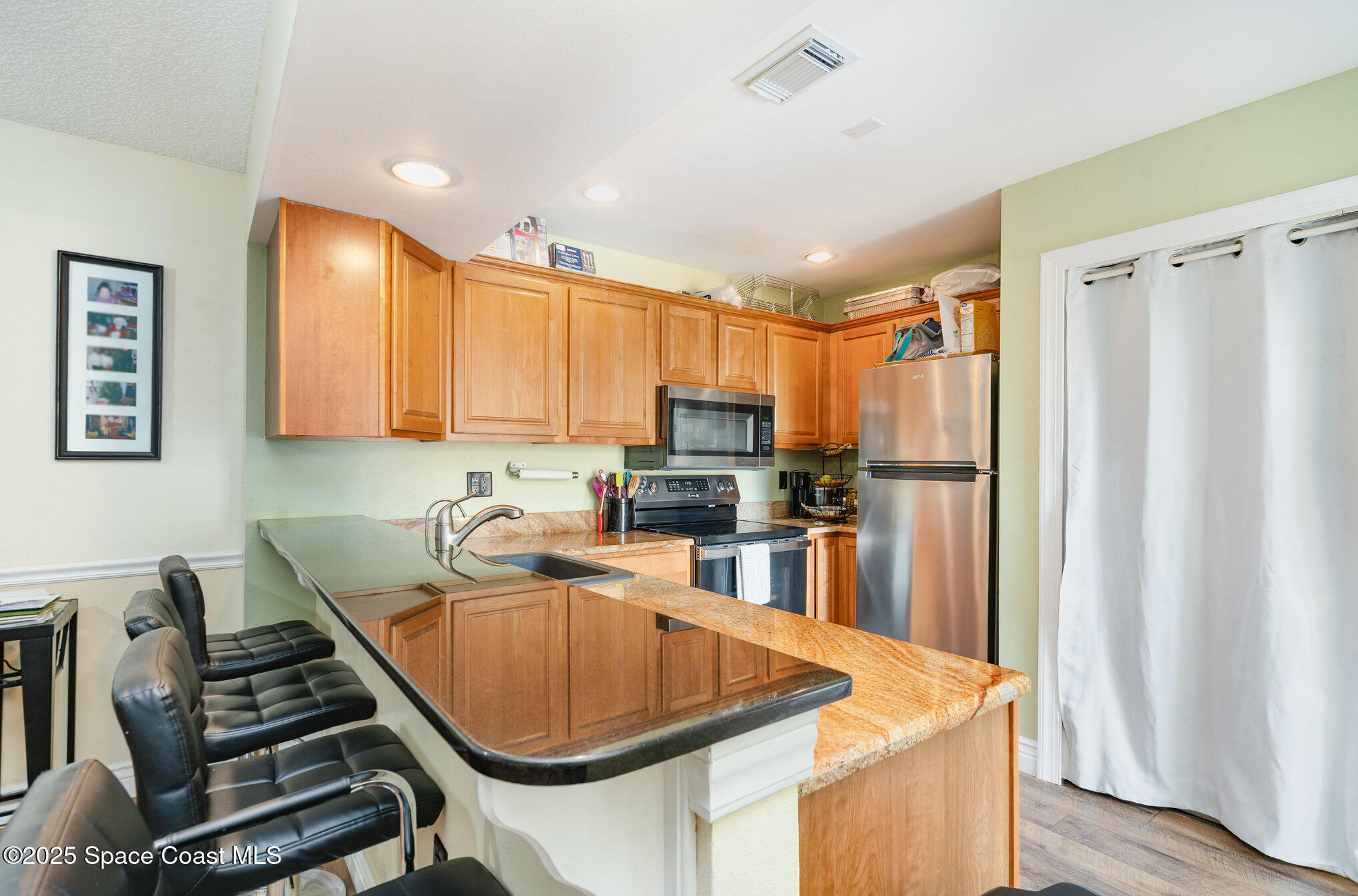 1010 Abada Court Northeast, Unit 102 Palm Bay, FL 32905 - Photo 6 of 37 a kitchen with stainless steel appliances granite countertop a sink stove and refrigerator