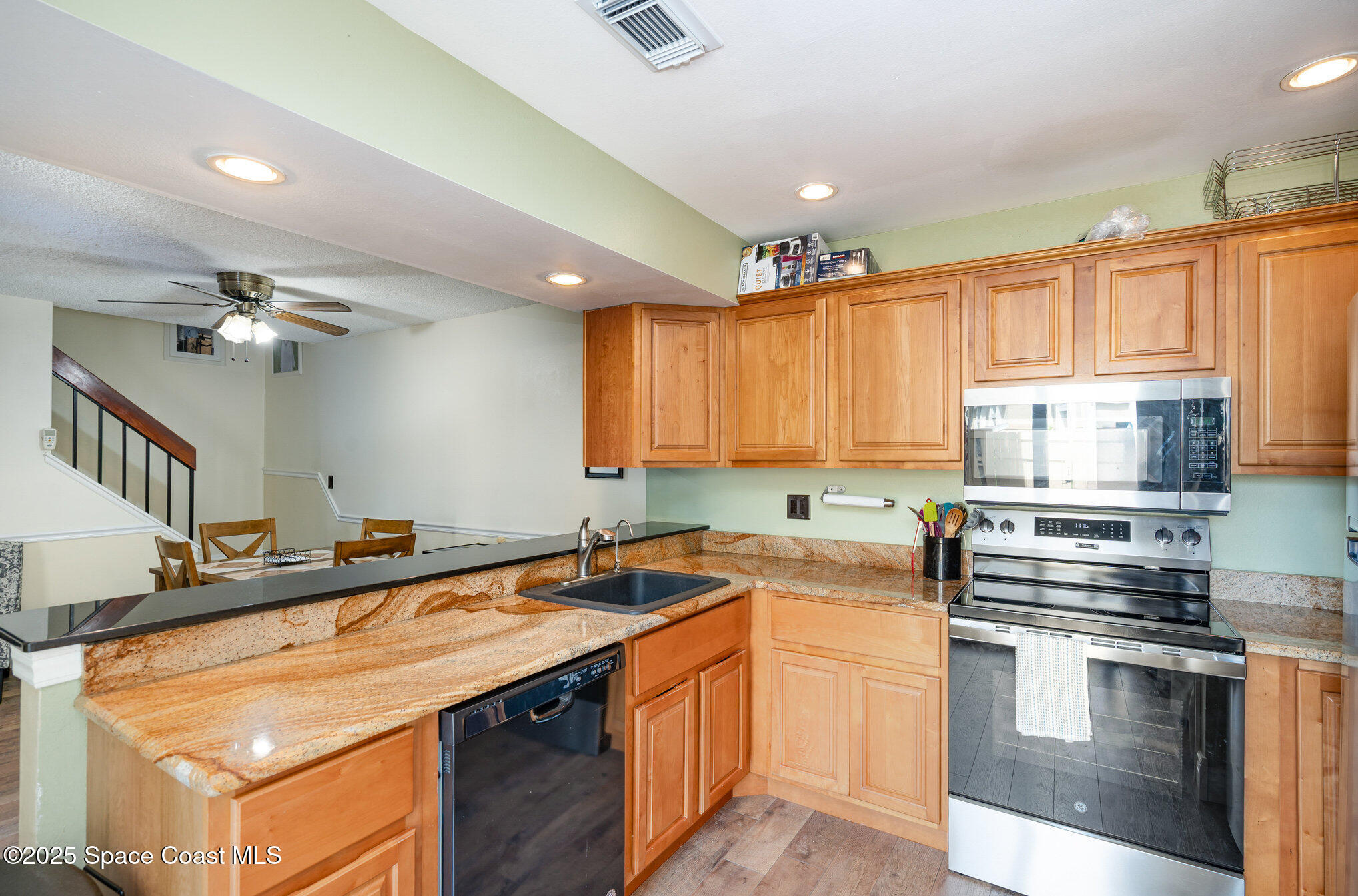 1010 Abada Court Northeast, Unit 102 Palm Bay, FL 32905 - Photo 7 of 37 a kitchen with stainless steel appliances granite countertop a sink stove and cabinets