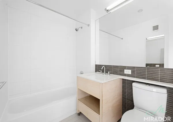 a bathroom with a sink toilet vanity and tub