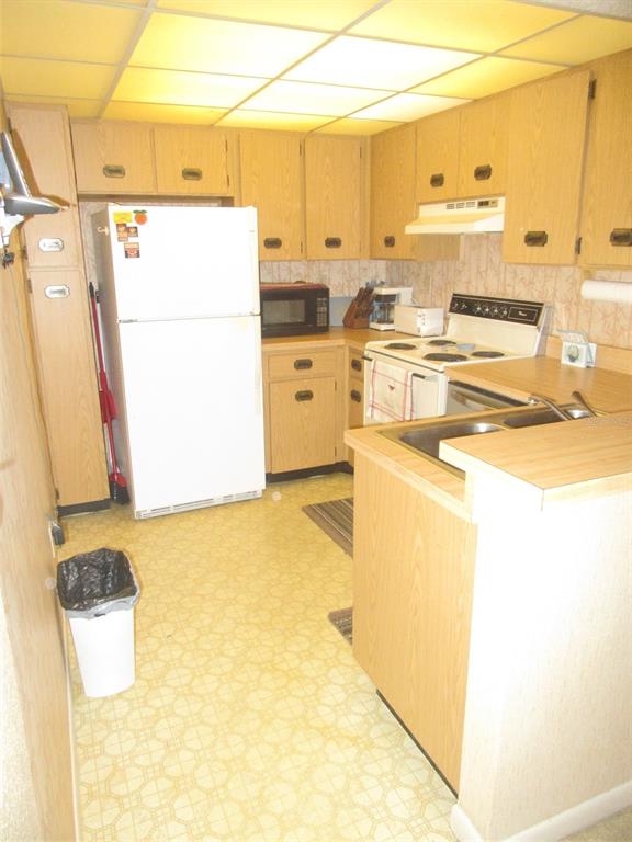 3006 Caring Way, Unit 422 Port Charlotte, FL 33952 - Photo 7 of 14 a kitchen with a sink a stove and a refrigerator