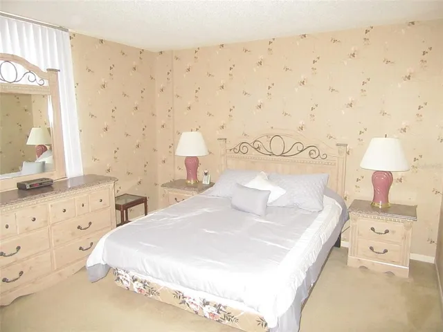 a bedroom with a bed and a lamp on the dresser