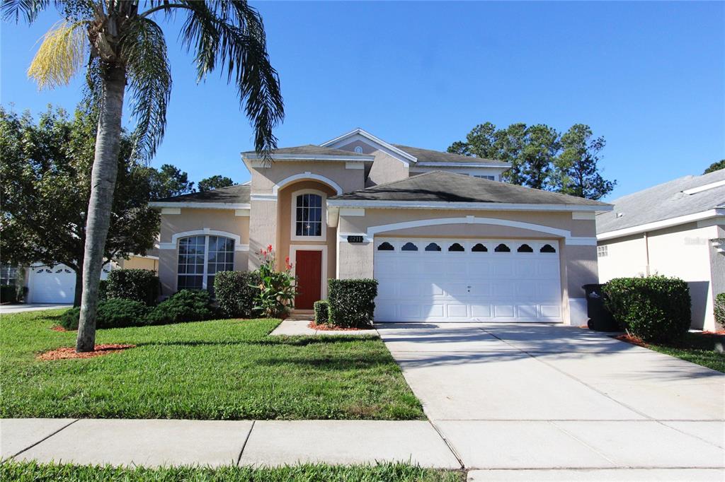 a front view of a house with a yard and a garage