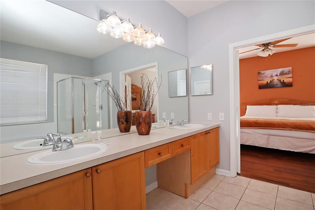 8211 Fan Palm Way Kissimmee, FL 34747 - Photo 20 of 41 a en suite bathroom with double vanity sink a mirror and a bathtub