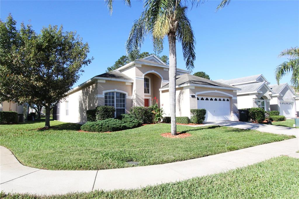 8211 Fan Palm Way Kissimmee, FL 34747 - Photo 2 of 41 a front view of a house with a garden and trees