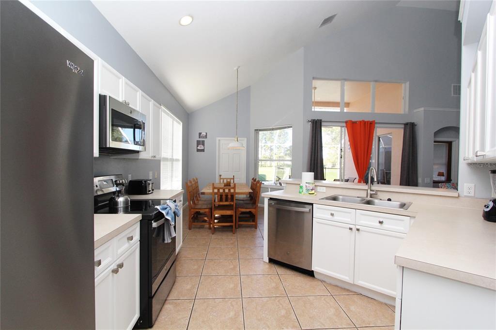 8211 Fan Palm Way Kissimmee, FL 34747 - Photo 6 of 41 a kitchen with stainless steel appliances a stove sink and cabinets