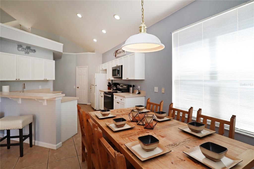 8211 Fan Palm Way Kissimmee, FL 34747 - Photo 9 of 41 a kitchen with a sink a stove and chairs