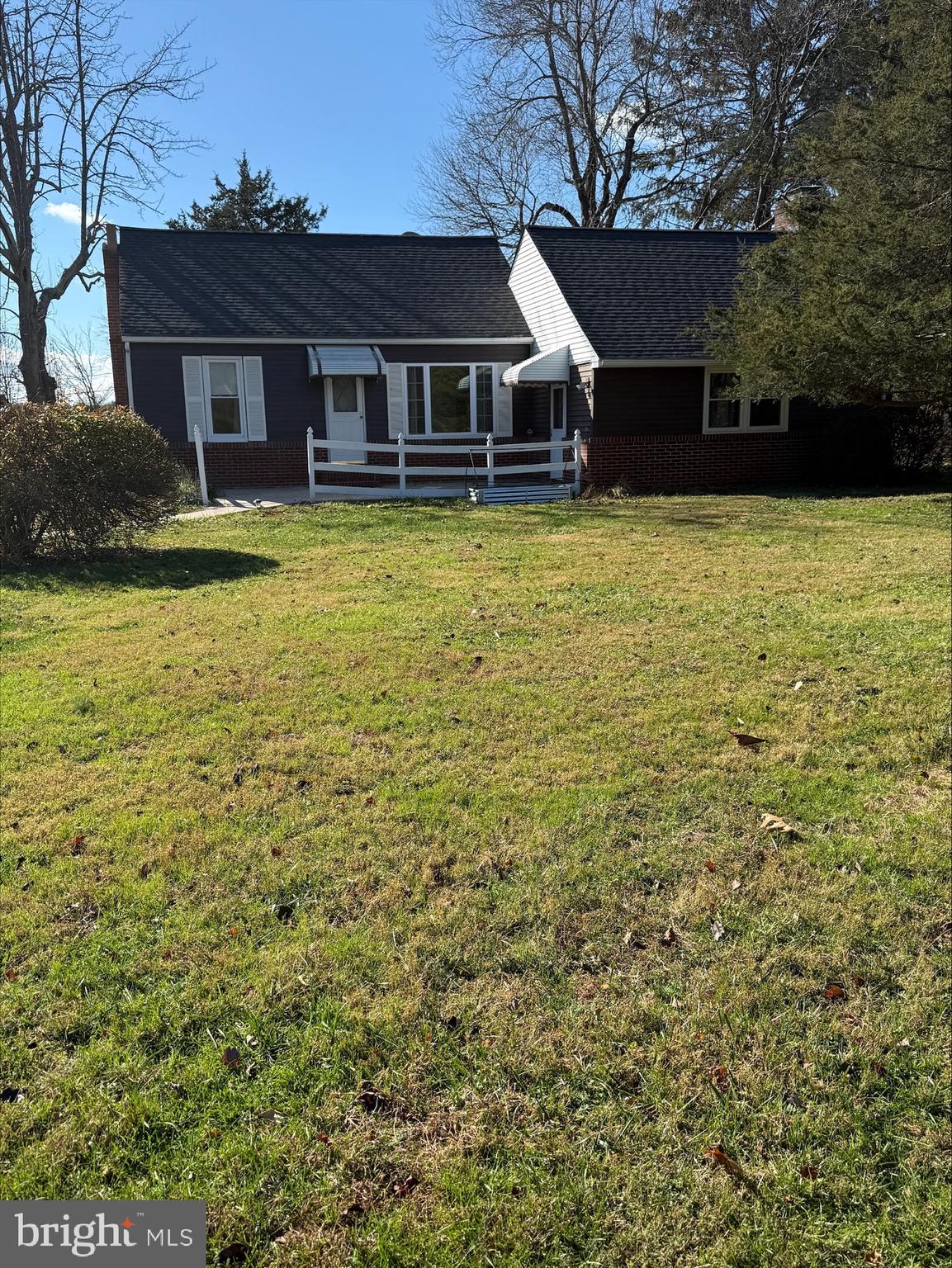 a view of a house with a yard covered with trees