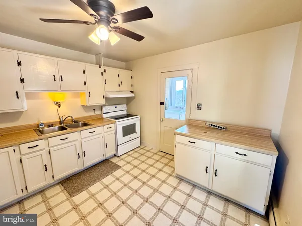 a large white kitchen with cabinets