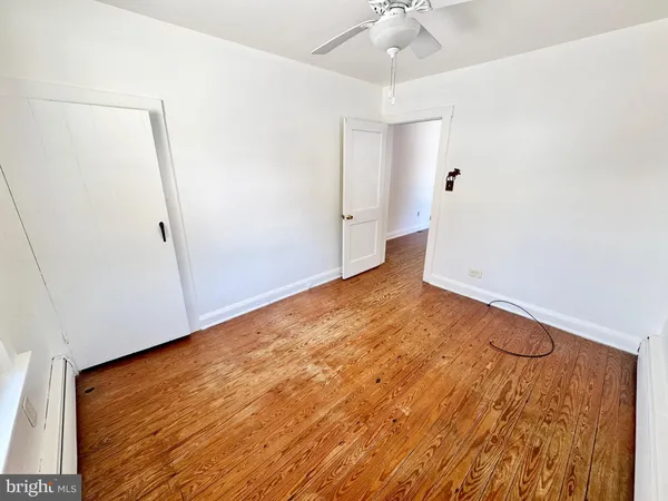 an empty room with a ceiling fan and carpet