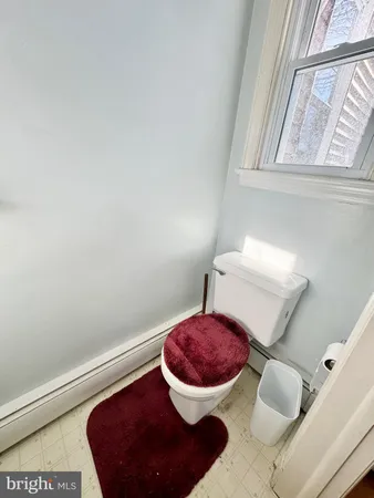 a bathroom with a toilet and a mirror