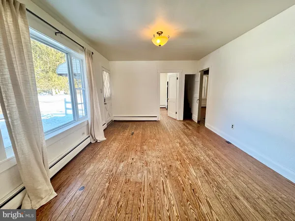 wooden floor in an empty room with a window