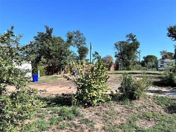a view of white house with a yard and tree in the background