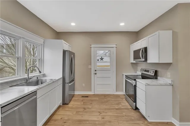a kitchen with granite countertop a refrigerator stove and sink