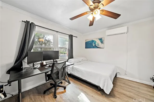 a bedroom with furniture a flat screen tv and a large window