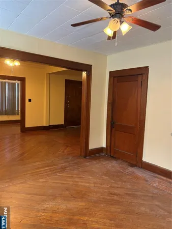 an empty room with closet and a chandelier fan