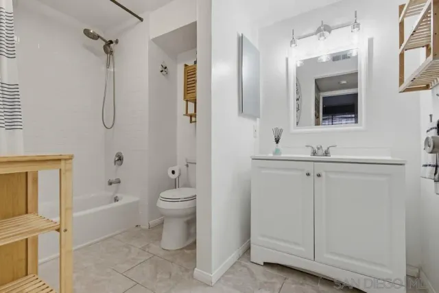 a bathroom with a granite countertop sink a toilet and shower