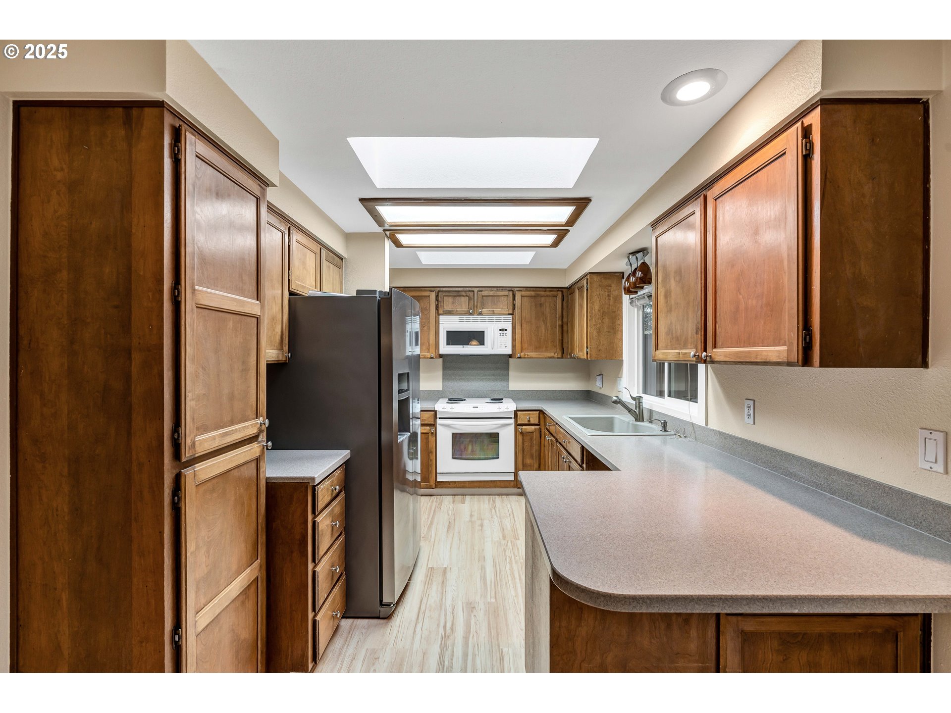 814 Northeast 196th Avenue Portland, OR 97230 - Photo 11 of 44 a kitchen with stainless steel appliances kitchen island a refrigerator sink and cabinets