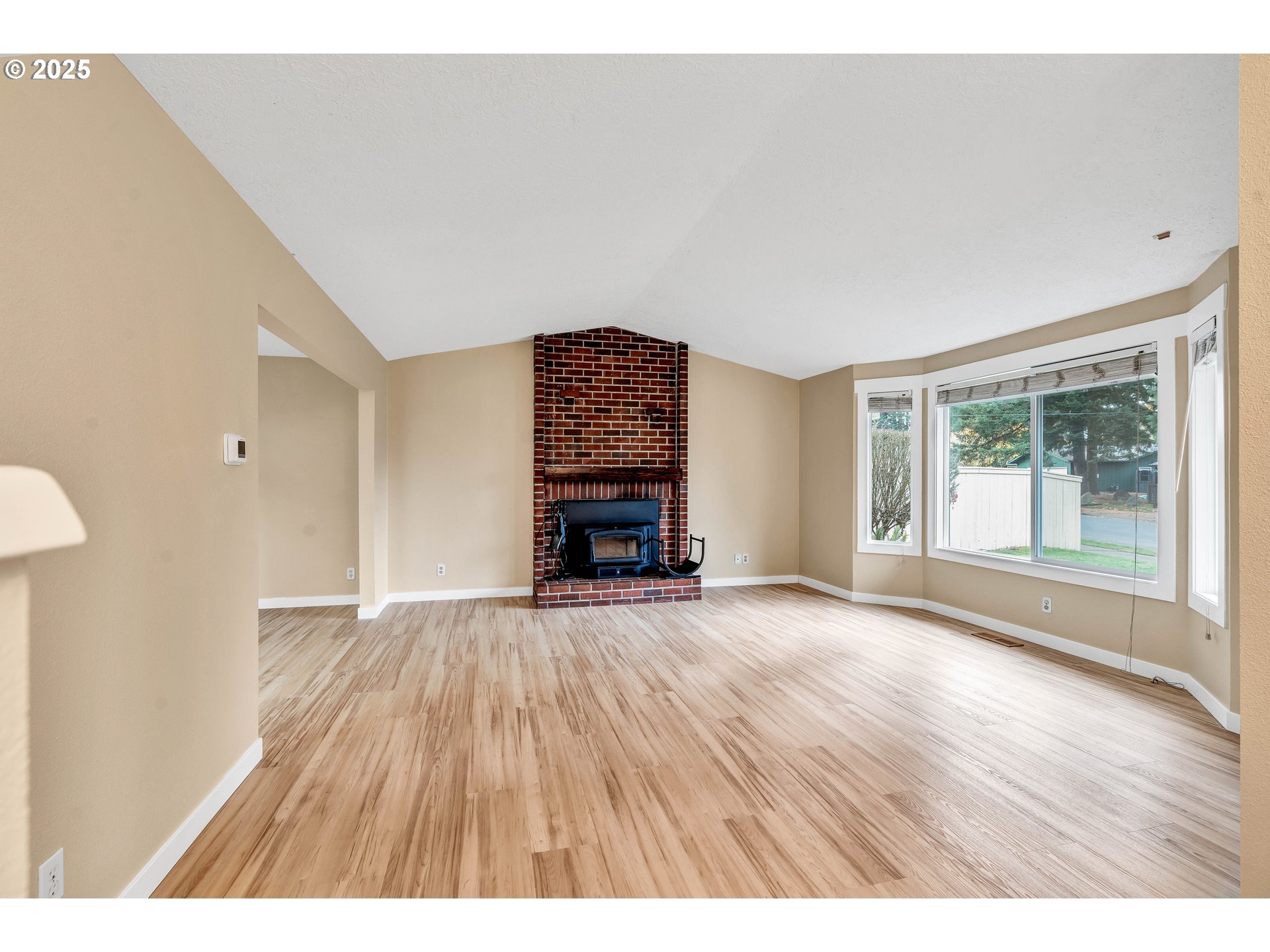 814 Northeast 196th Avenue Portland, OR 97230 - Photo 6 of 44 a view of an empty room with wooden floor fireplace and a window