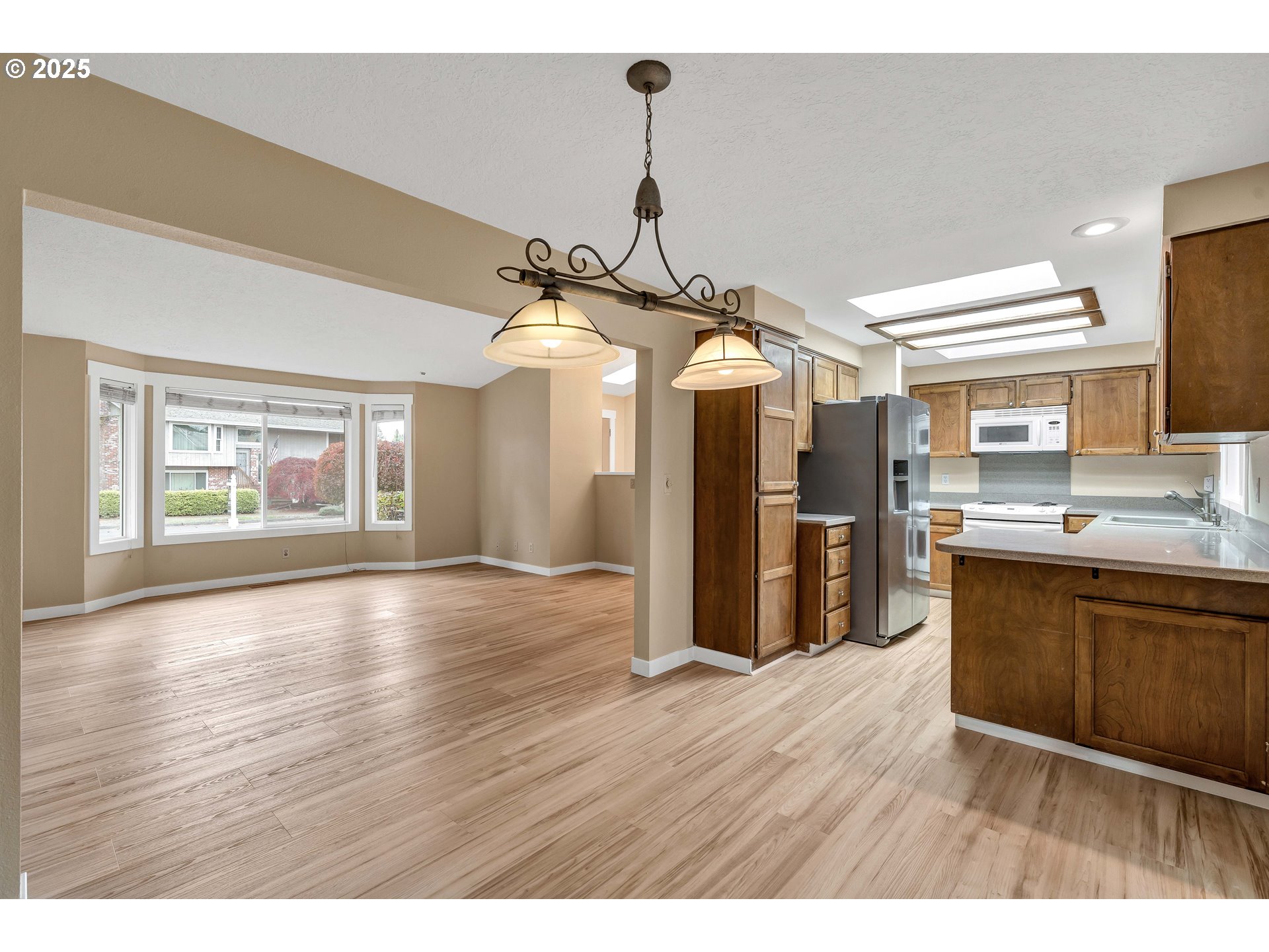 814 Northeast 196th Avenue Portland, OR 97230 - Photo 10 of 44 a kitchen with stainless steel appliances granite countertop a refrigerator a sink dishwasher a stove and white countertops with wooden floor