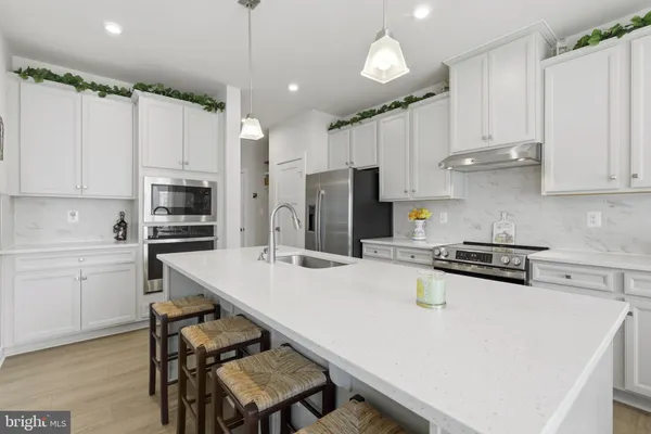 a kitchen with kitchen island a stove a sink and a refrigerator