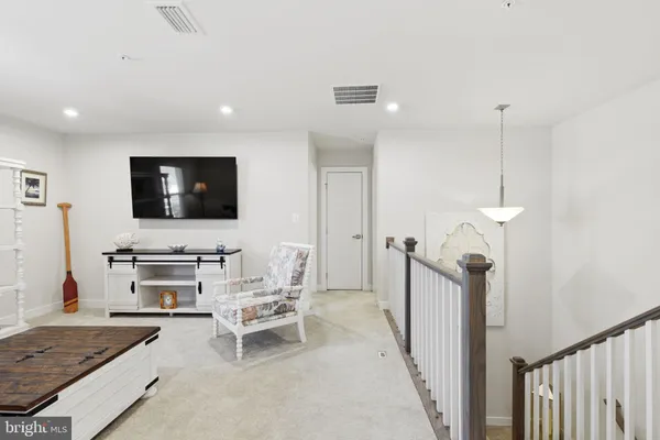 a bedroom with a bed a chair and a chandelier