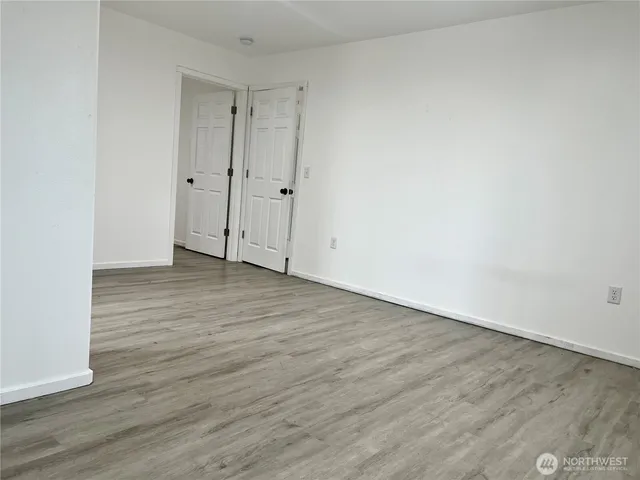a view of an empty room with wooden floor