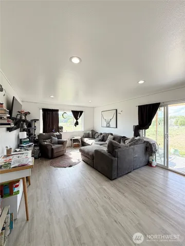 a living room with furniture a flat screen tv and a wooden floor