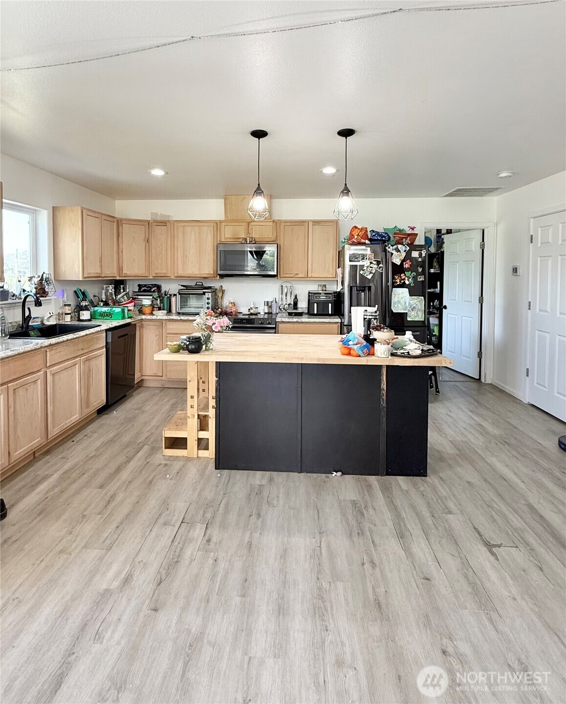 38 Miller Road Omak, WA 98841 - Photo 6 of 29 a kitchen with stainless steel appliances granite countertop a sink dishwasher a stove and white cabinets with wooden floor