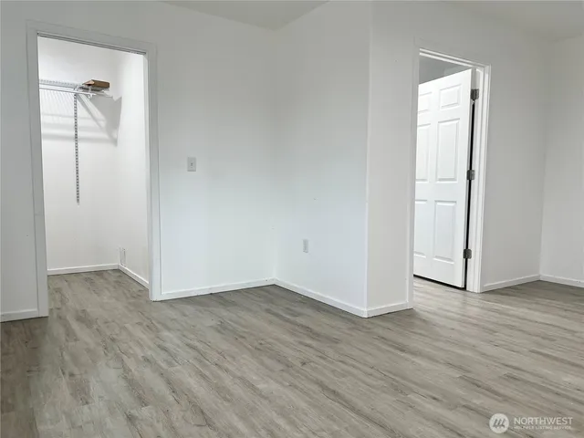an empty room with wooden floor and closet
