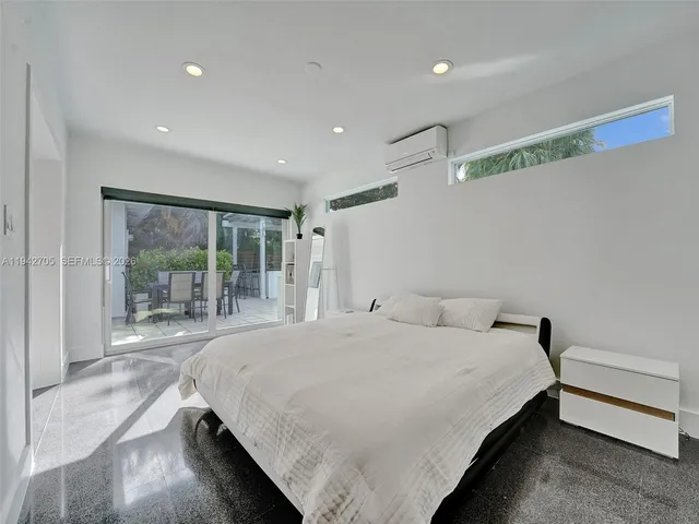 a bedroom with a bed and large window