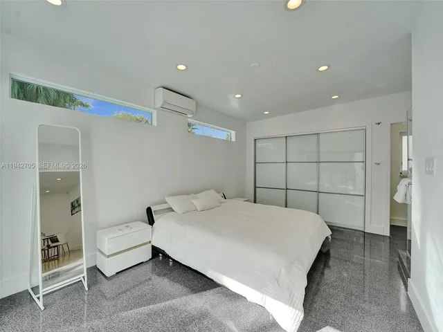 a bedroom with a bed and a refrigerator