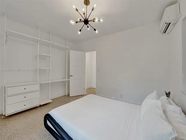 a bedroom with a bed and a chandelier fan