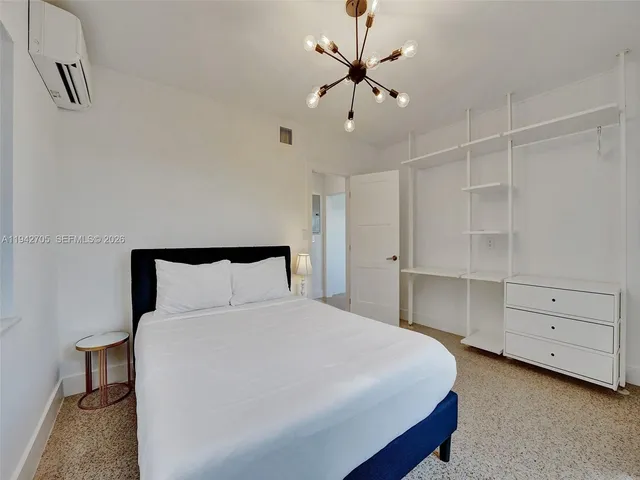 a bedroom with a large bed and a chandelier