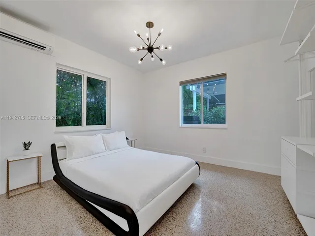 a bedroom with a bed dresser and a window