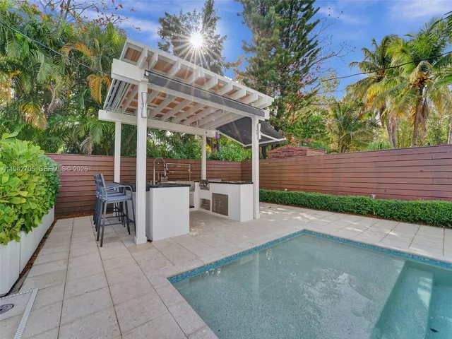 a view of a patio with a table and chairs under an umbrella