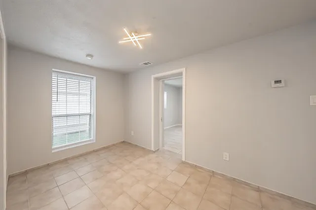 an empty room with windows and closet