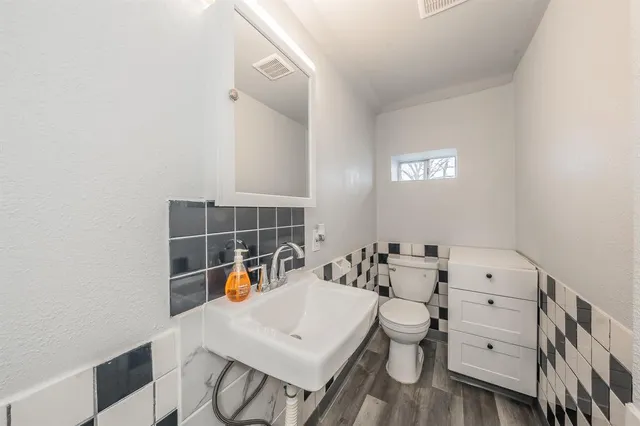 a bathroom with a sink a toilet and a mirror